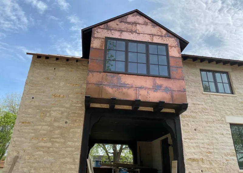 Copper metal panel facade on a stone building for Roof Repair in Cascade